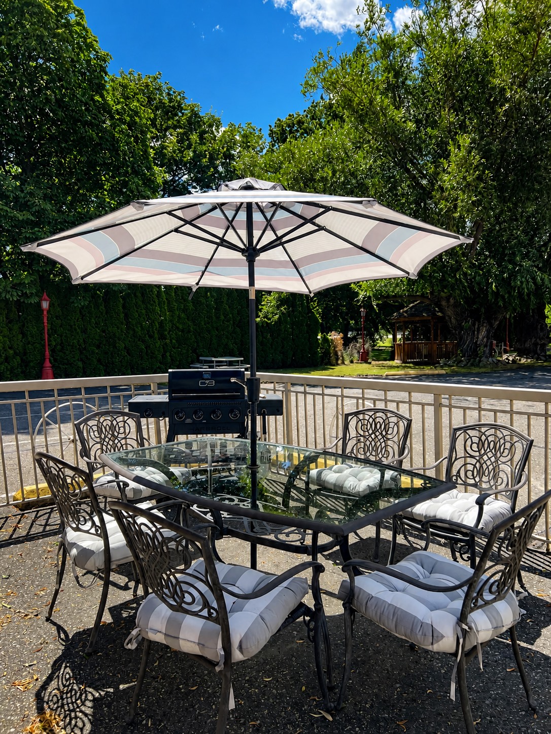 Outdoor patio with barbecue, dining table, umbrella, and gazebo at Overlander Motel